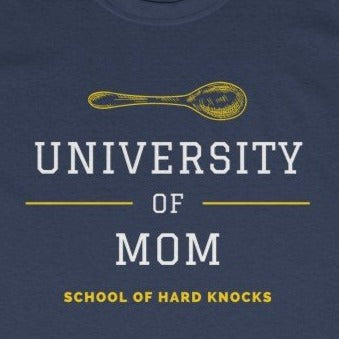 Navy tee shirt with yellow spoon and embellishments and white and yellow wording: University of mom, school of hard knocks